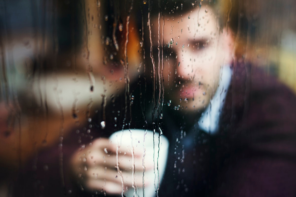 man-looking-out-rain