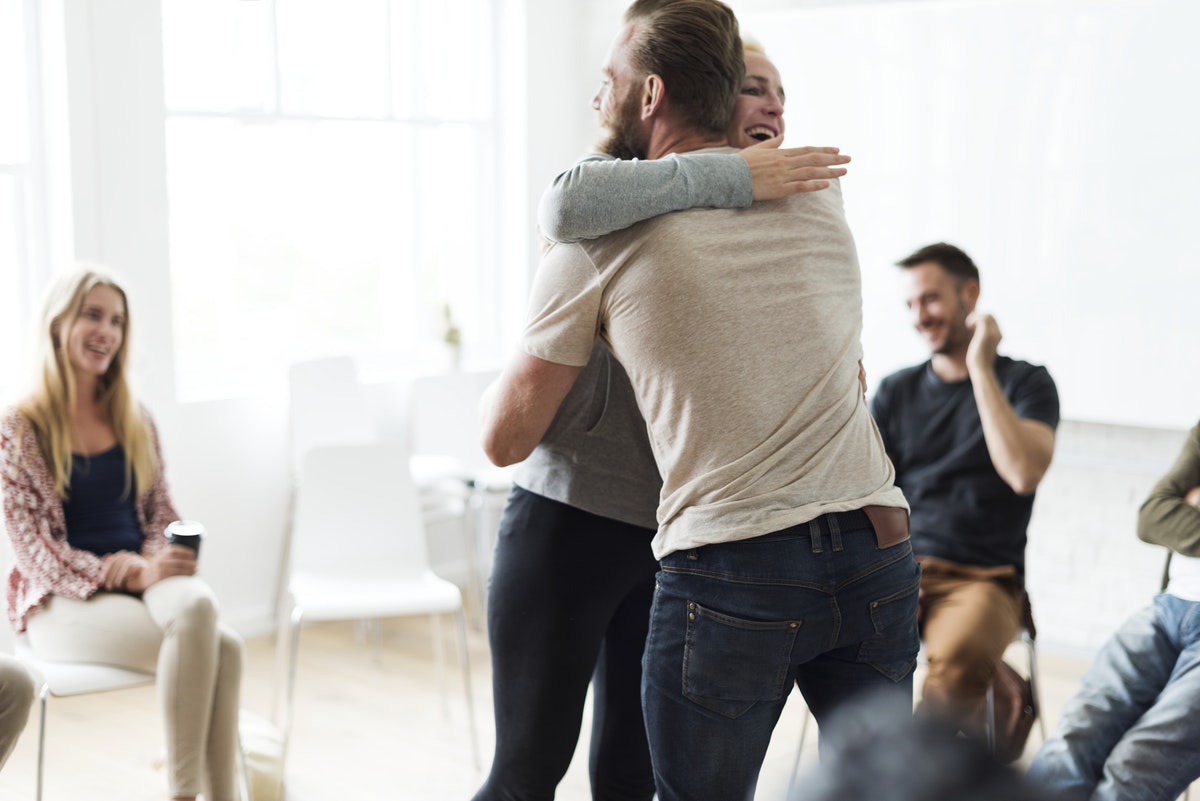 people in a support group hugging