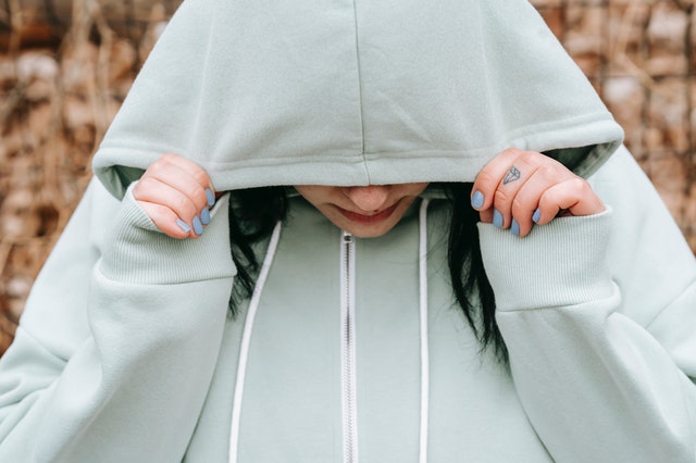 teen pulling hoodie over head